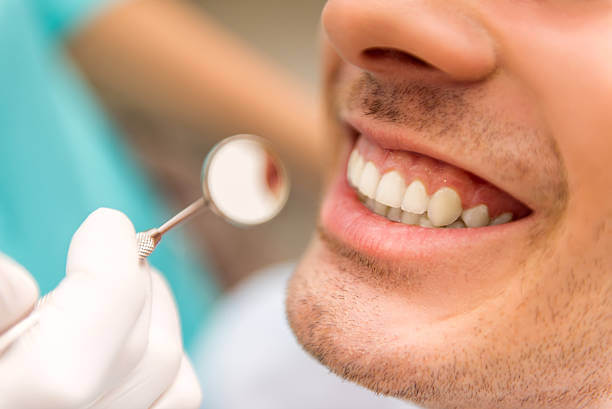 dental professional examines a patient’s mouth during a dental assessment